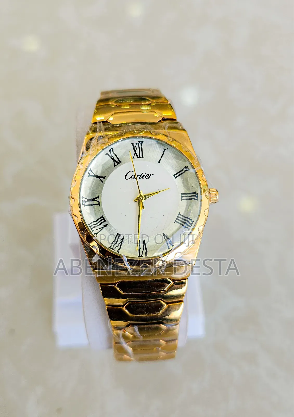 Gold-Colored Wristwatch With a White Dial and Roman Numerals