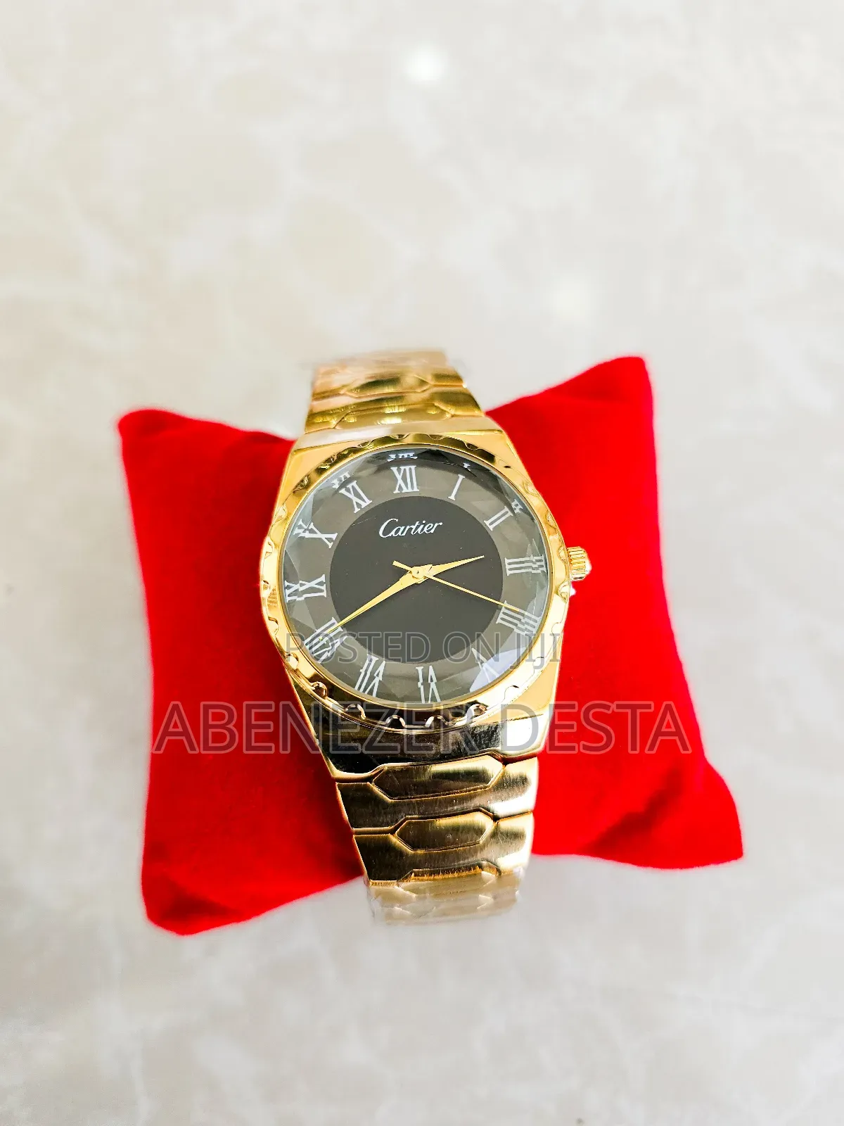 Gold-Tone Watch With a Black Face and Roman Numerals.