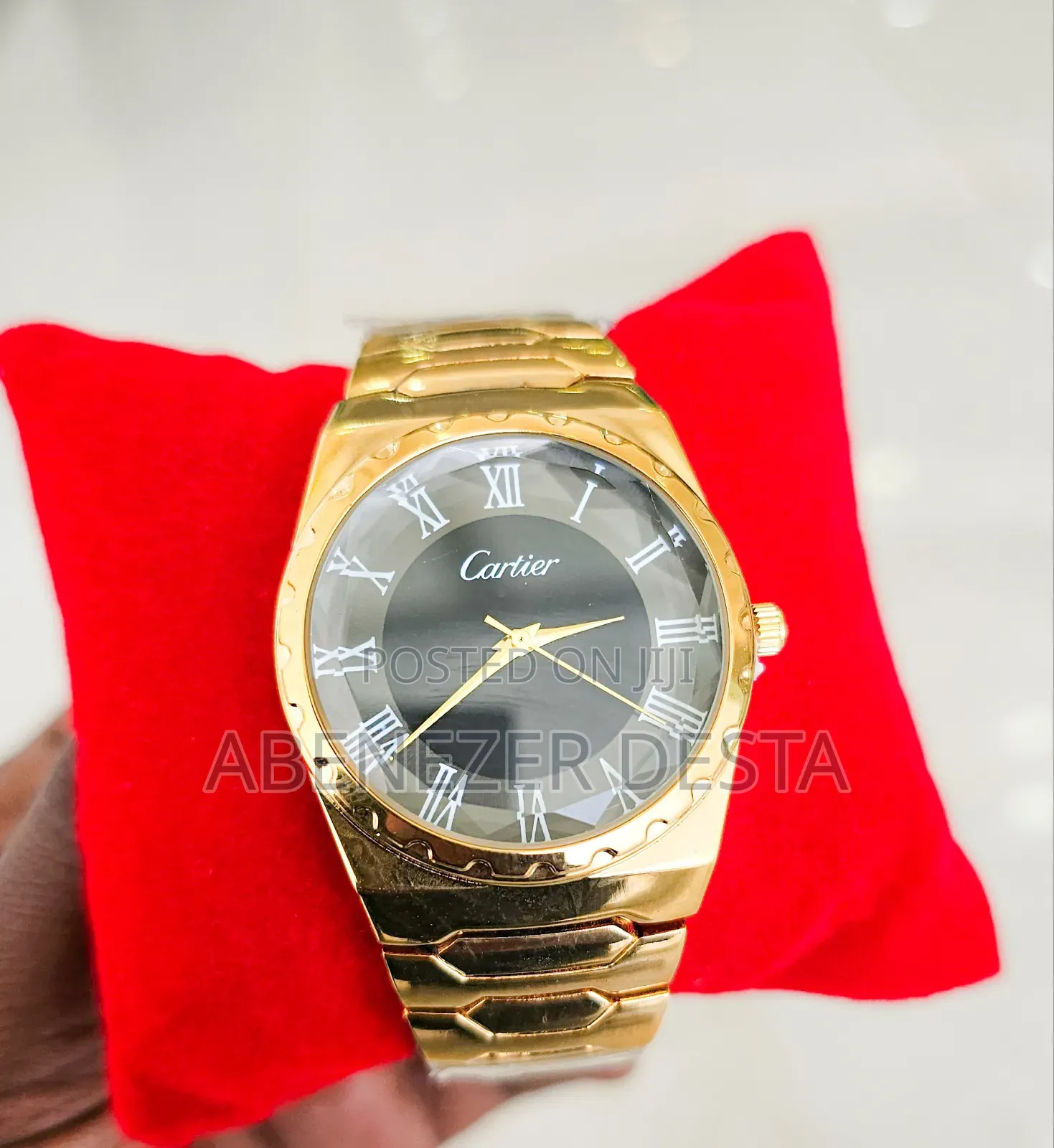 Gold-Tone Watch With a Black Face and Roman Numerals.