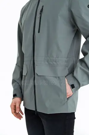 The Main Body of the Jacket Is a Muted Grey or Light Green Color.