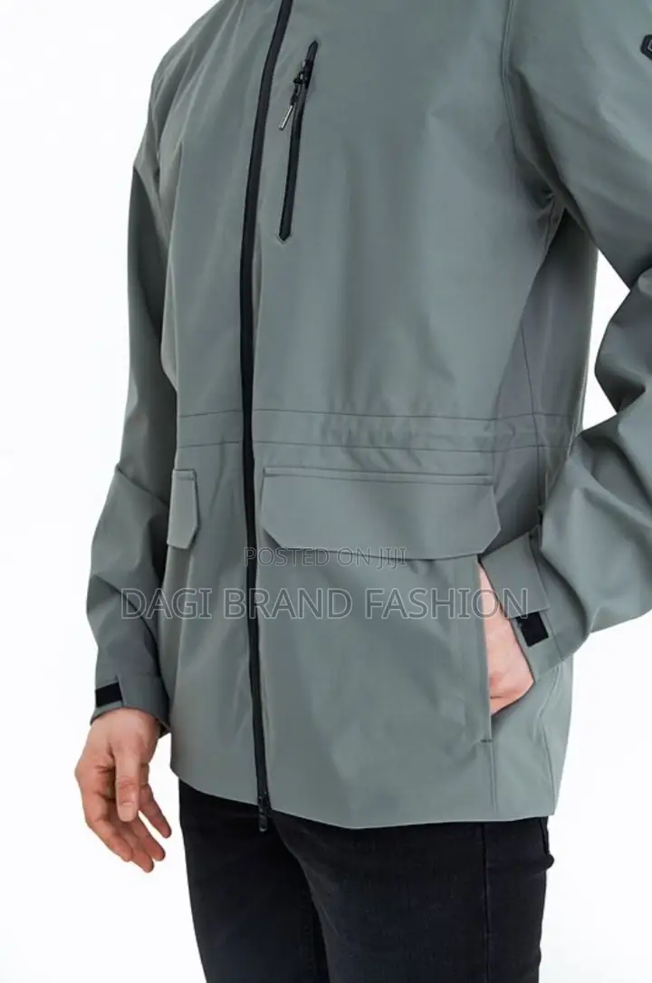 The Main Body of the Jacket Is a Muted Grey or Light Green Color.