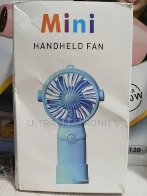 Mini Handheld Fan Packaged in Its Product Box. T
