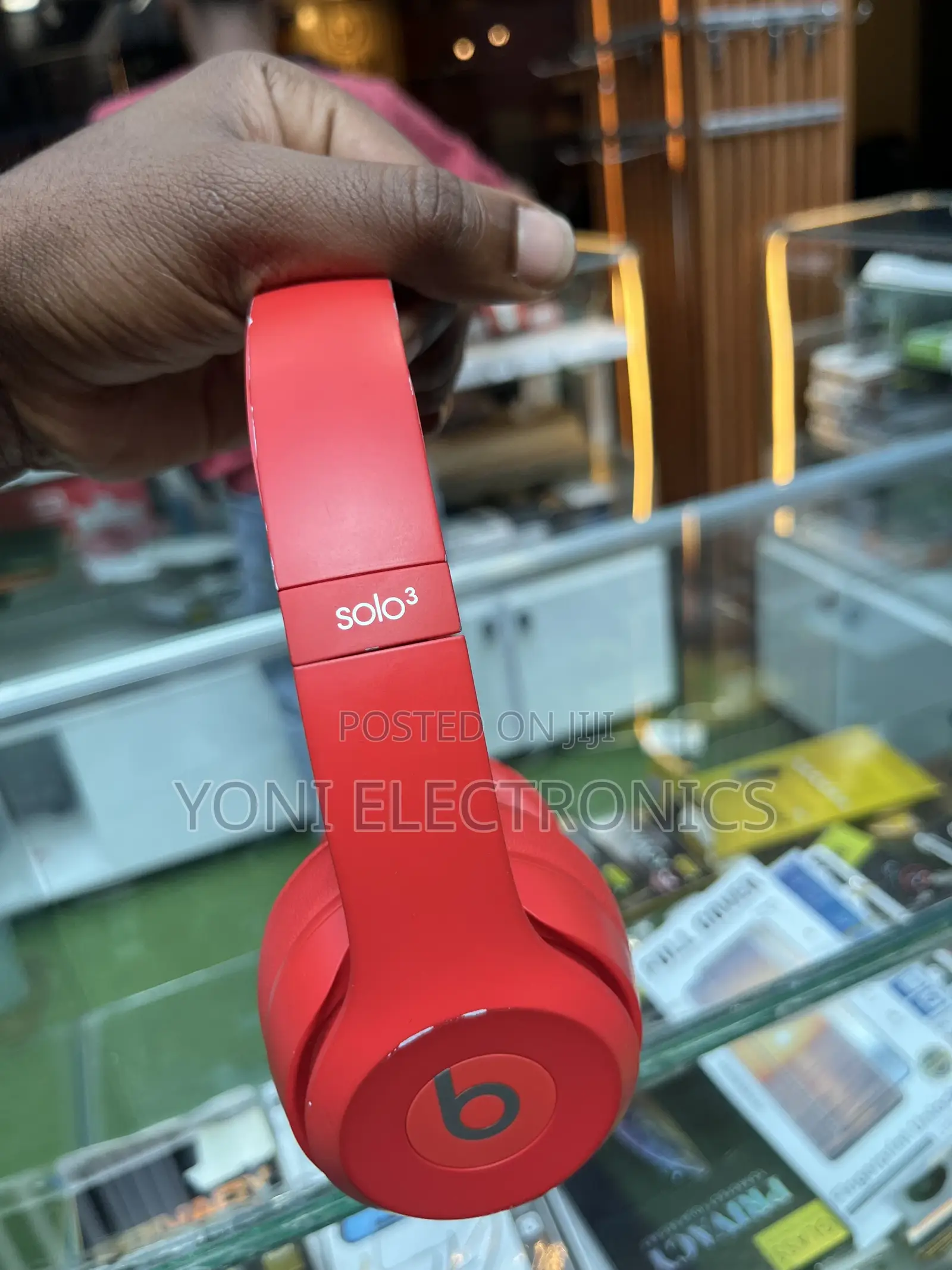 Hand Holding Red Beats Solo Headphones