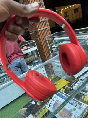 Hand Holding Red Beats Solo Headphones