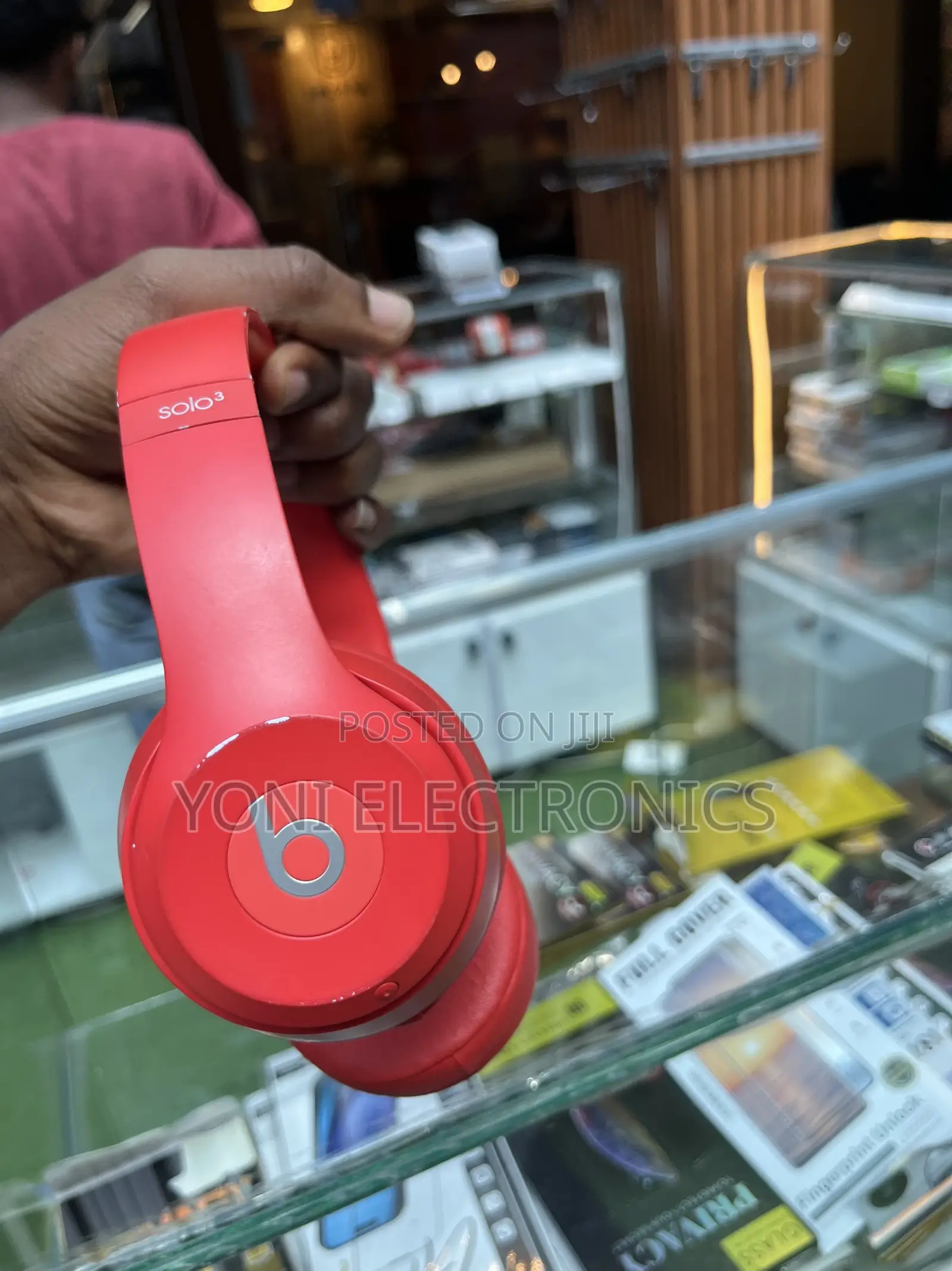 Hand Holding Red Beats Solo Headphones