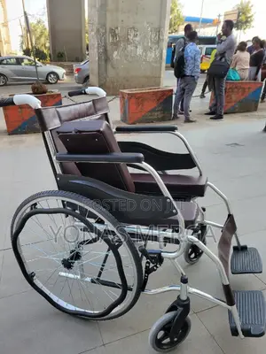 Toilet Wheelchair凹it Features a Brown Leather Seat and a Silver Frame.