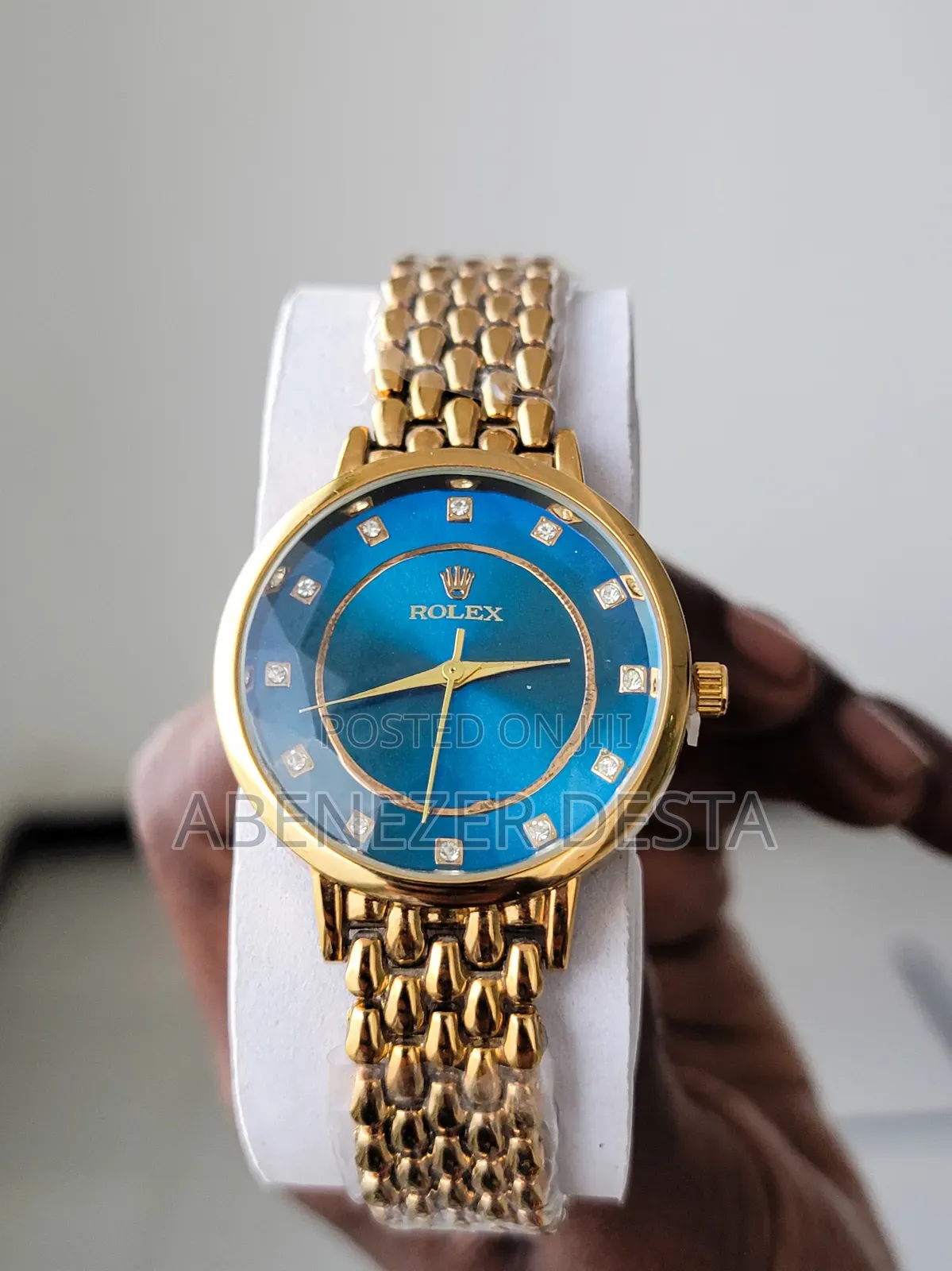 Gold-Toned Rolex Watch With a Blue Dial and Diamond Hour Markers.