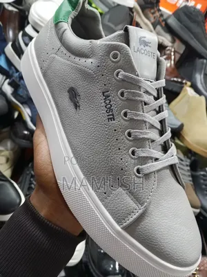 This Is Apair of Black Lacoste Leather Snickers With a White Sole